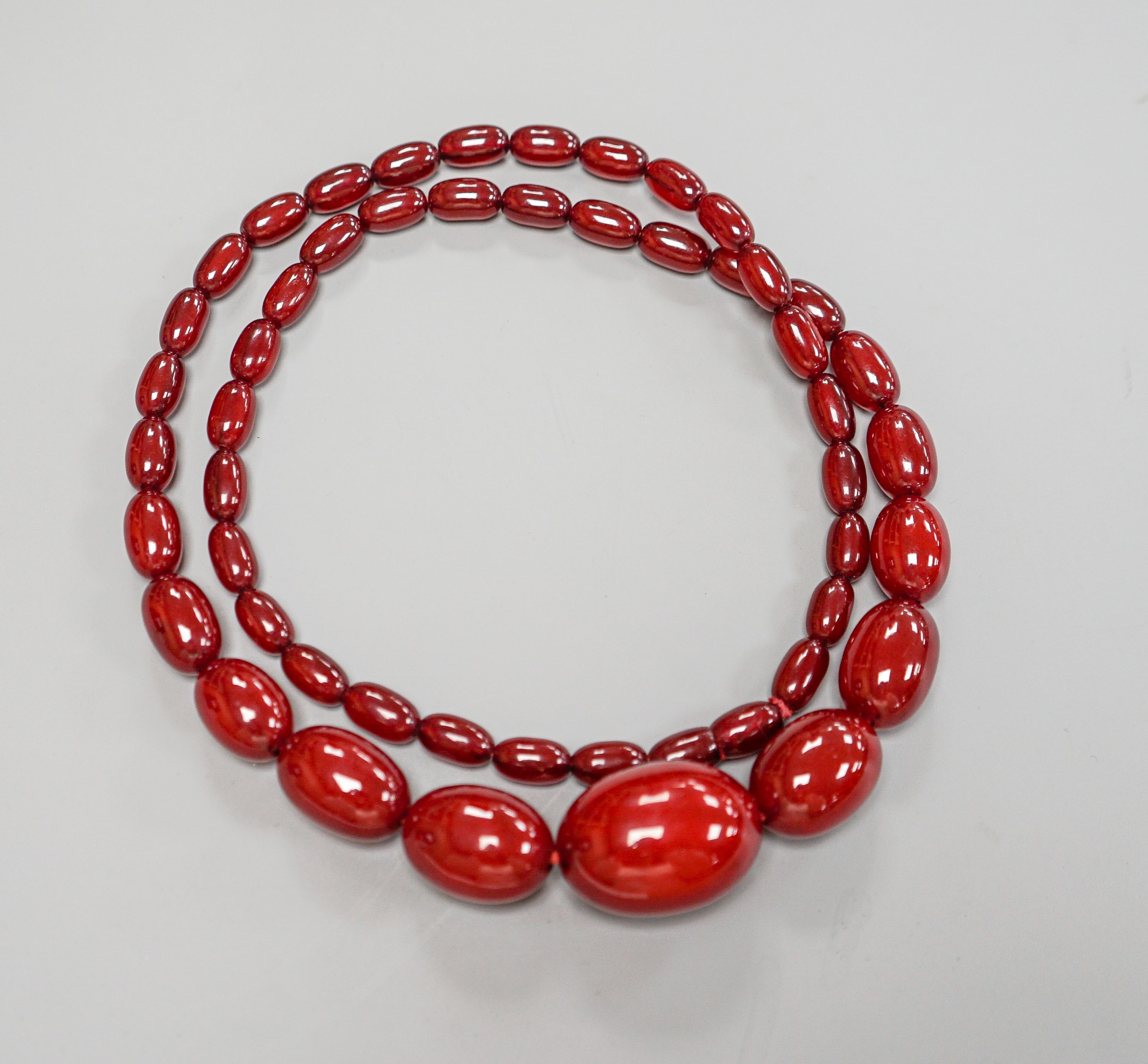 A single strand graduated simulated cherry amber bead necklece, 72cm, gross weight 63 grams.